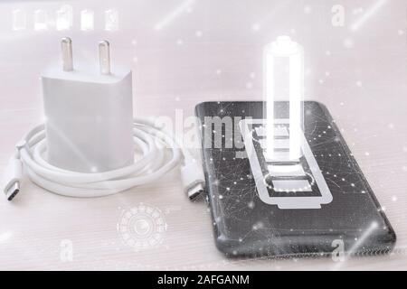 Photo of mobile phone and charger. Isolated on a white background. Stock Photo