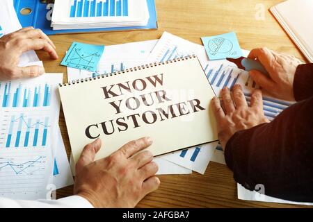 Know your customer sign. Businessmen read marketing report. Stock Photo