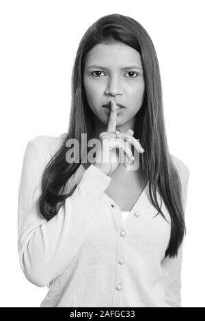 Close up of young beautiful Brazilian woman with finger on lips Stock Photo