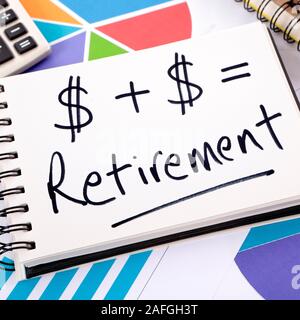 Simple retirement formula written on a notepad surrounded by graphs, charts, calculator, books and pencils. Stock Photo