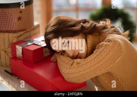 Pretty woman in knitted sweater feeling tired Stock Photo