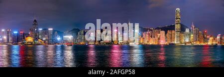 Panorama of high-rise waterfront buildings illuminated at night. Hong Kong, China. Stock Photo