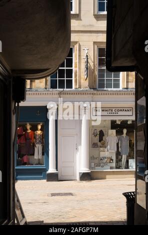 Glimpse view of Stamford High Street between overhanging buildings of the very narrow Cheyne Lane walkway, Stamford, Lincolnshire, England, UK Stock Photo
