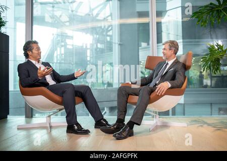 Two businessmen talking in office Stock Photo