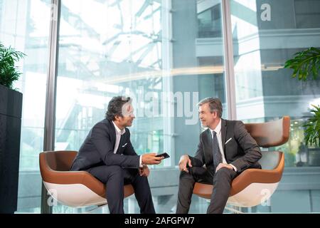 Businessmen using smartphone in office Stock Photo