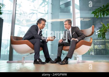 Businessmen using smartphone in office Stock Photo