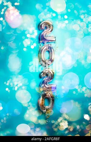 Balloon Bunting for celebration of New Year 2020 made from Silver Number Balloons. Holiday Party Decoration or postcard concept with top view and copy space. Toned in blue color Stock Photo