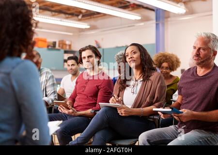 Group Making Notes Whilst Attending Neighborhood Meeting In Community Center Stock Photo
