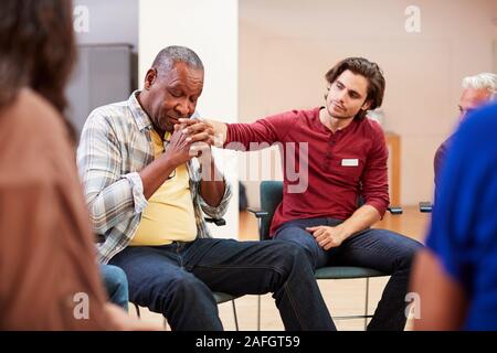 Unhappy Man Attending Self Help Therapy Group Meeting In Community Center