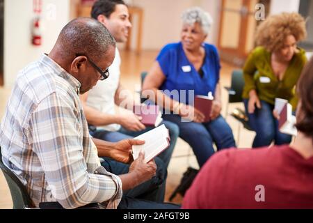 People Attending Bible Study Or Book Group Meeting In Community Center Stock Photo