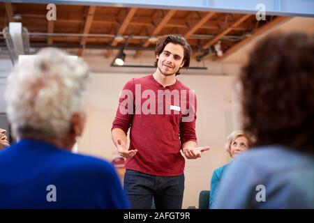 Man Standing To Address Self Help Therapy Group Meeting In Community Center Stock Photo
