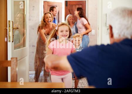 Multi Generation Family With Grandchildren Visiting Grandparents At Home Stock Photo