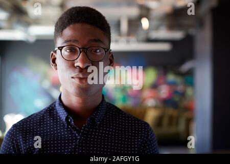 Young black male creative in casual office lounge area looking to camera, close up Stock Photo