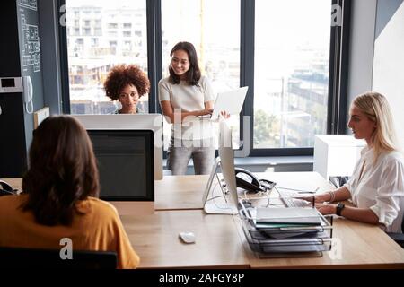 Four creative female colleagues working together in a creative office, close up Stock Photo