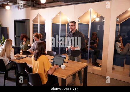 Creative business colleagues drinking coffee and talking in their office canteen Stock Photo