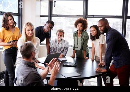 Creative business team listening to colleague at a brainstorm meeting Stock Photo