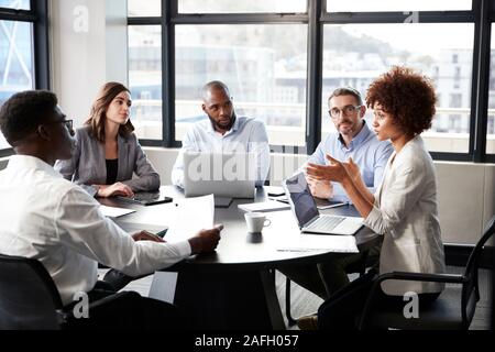 Millennial black businesswoman addressing colleagues at a corporate business meeting, close up Stock Photo