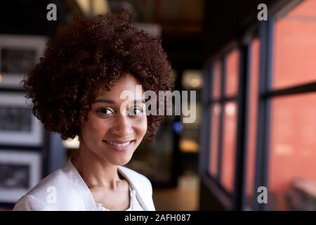 Millennial black businesswoman smiling to camera by the window in an office, close up Stock Photo
