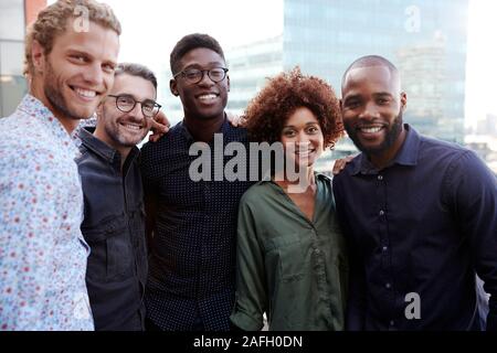 Happy creative business colleagues smiling to camera outdoors, waist up, close up Stock Photo