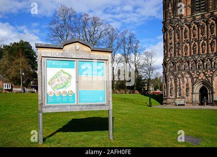 Cathedral plan and service times sign outside with part of the Cathedral to the right hand side, Lichfield, Staffordshire, England, UK. Stock Photo