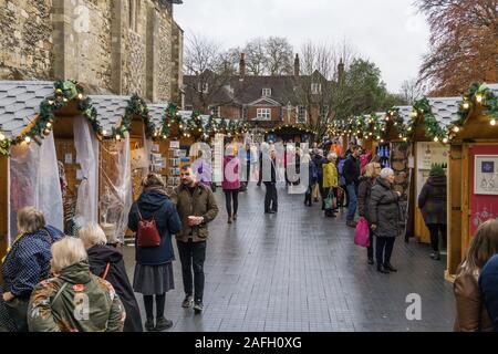 Visitors to Winchester Christmas Market next to the Cathedral, Winchester, Hampshire, UK Stock Photo