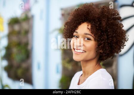 Outdoor Head And Shoulders Portrait Of Smiling Young Woman Stock Photo