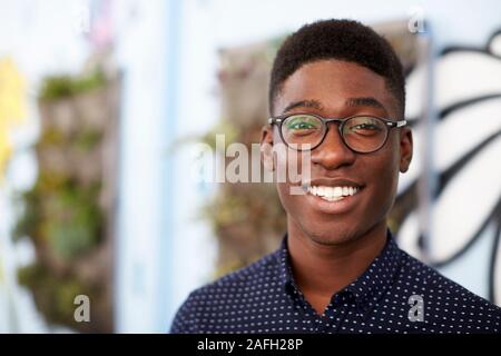 Outdoor Head And Shoulders Portrait Of Smiling Young Man Stock Photo