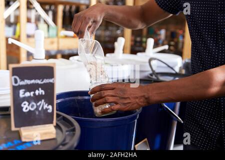 Man Filling Container With Natural Home Products In Plastic Free Grocery Store Stock Photo
