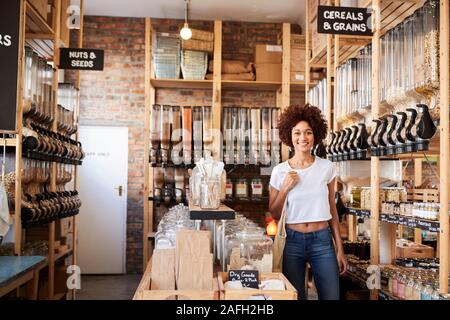 Portrait Of Woman Buying Dry Goods In Sustainable Plastic Free Grocery Store Stock Photo