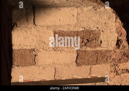section of a rust red mud brick wall of the canaanite temple ruins at tel hazor in israel showing the texture and pattern detail including bits of str Stock Photo