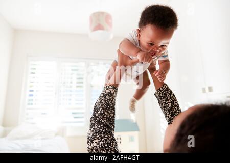 Proud Mother Cuddling Baby Son In Nursery At Home Stock Photo