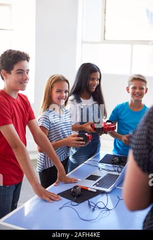Group Of Students In After School Computer Coding Class Learning To Program Robot Vehicle Stock Photo