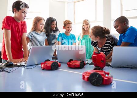 Group Of Students In After School Computer Coding Class Learning To Program Robot Vehicle Stock Photo