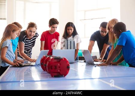 Group Of Students In After School Computer Coding Class Learning To Program Robot Vehicle Stock Photo