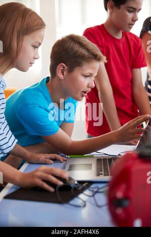 Group Of Students In After School Computer Coding Class Learning To Program Robot Vehicle Stock Photo