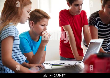 Group Of Students In After School Computer Coding Class Learning To Program Robot Vehicle Stock Photo