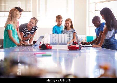 Group Of Students In After School Computer Coding Class Learning To Program Robot Vehicle Stock Photo