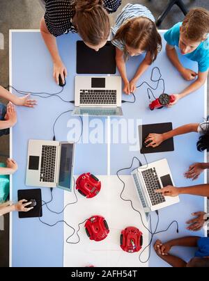 Overhead View Of Students In After School Computer Coding Class Learning To Program Robot Vehicle Stock Photo