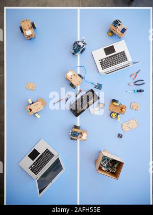 Overhead View Of Laptops And Robotic Vehicles On Table In School Computer Coding Class Stock Photo
