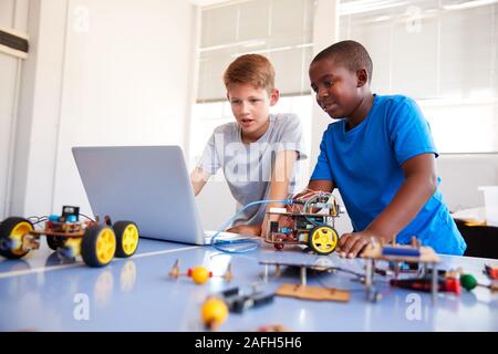 Two Male Students Building And Programing Robot Vehicle In After School Computer Coding Class Stock Photo