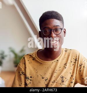 Portrait Of Smiling Young Man In Loft Apartment Stock Photo