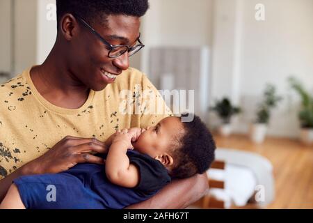 Loving Father Holding Newborn Baby At Home In Loft Apartment Stock Photo