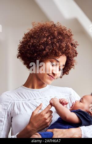 Loving Mother Holding Newborn Baby At Home In Loft Apartment Stock Photo