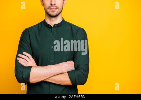 Photo of confident candid man in green shirt outfit standing confidently with hands folded having bristle on face expressing no emotions isolated Stock Photo