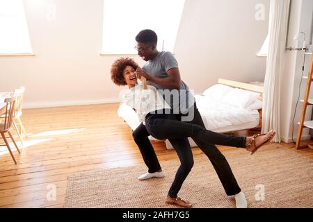 Couple Having Fun In New Home Dancing Together Stock Photo