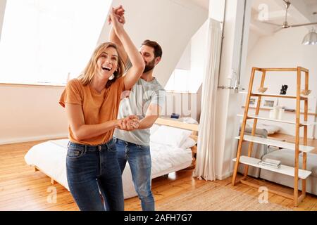 Couple Having Fun In New Home Dancing Together Stock Photo