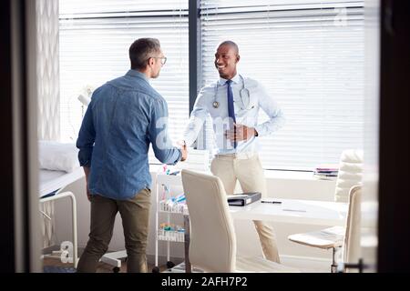 Mature Male Patient Shaking Hands With Doctor In Office Stock Photo