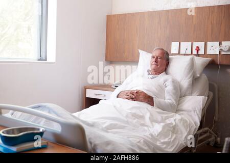 Senior Male Patient In Hospital Bed In Geriatric Unit Stock Photo