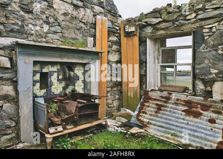 Tiled area with flue and rusting cooker in an abandoned crofters house, Isle of Lewis and Harris, Outer Hebrides, Scotland Stock Photo