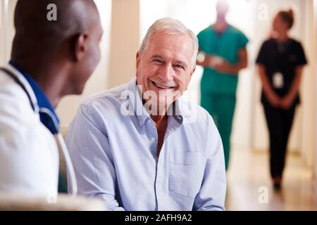 Doctor Welcoming To Senior Male Patient Being Admitted To Hospital Stock Photo